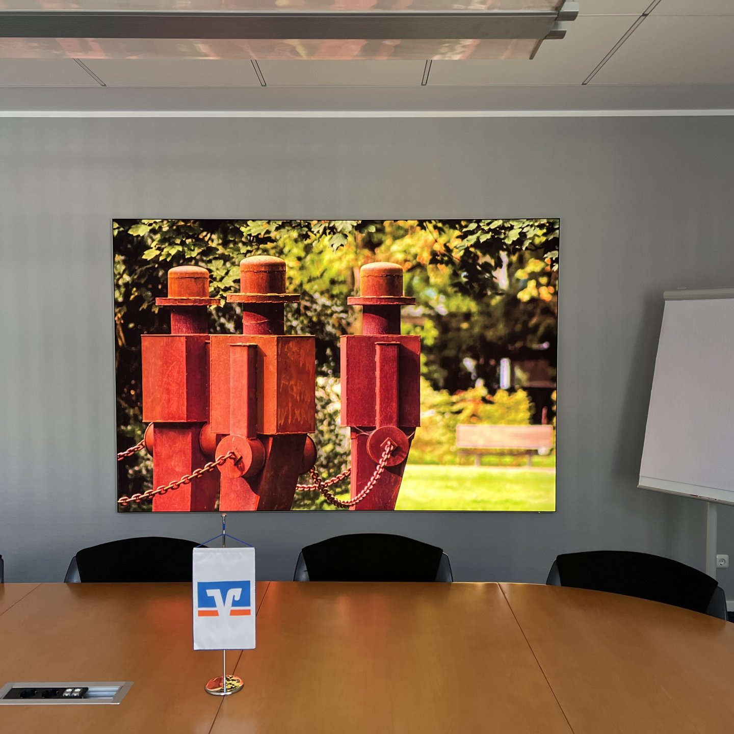 Großer LED-Leuchtrahmen mit rotem Regionalmotiv im Besprechungsraum der Volksbank Viersen eG